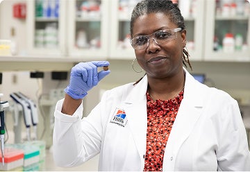 Hill’s Pet Nutrition Center Researcher with a pet food kibble in her hand